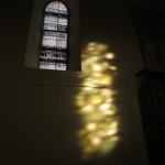 Lumière d'un vitrail sur le mur un matin